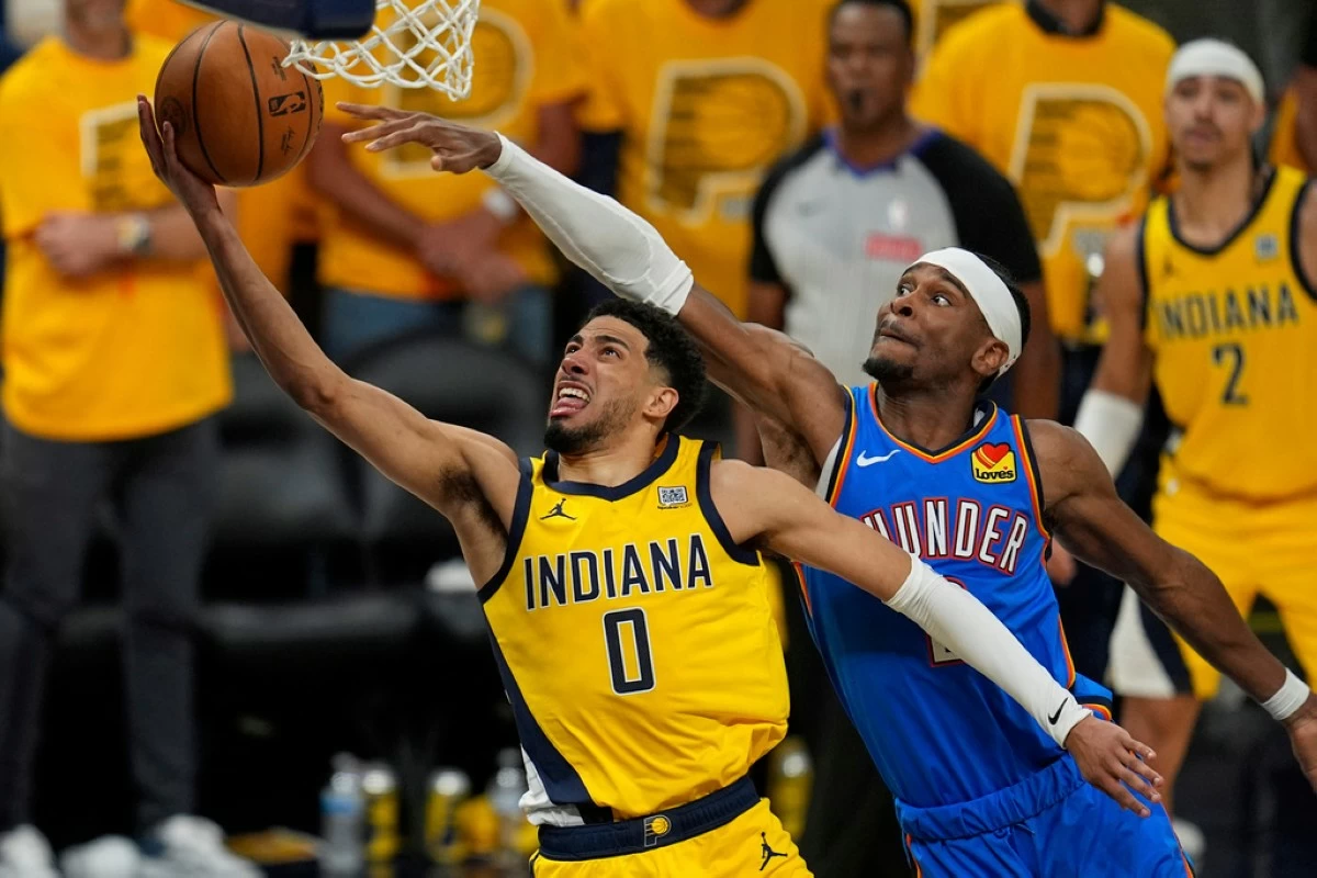 Indiana Pacers guard Tyrese Haliburton (0) shoots under Oklahoma City Thunder guard Shai Gilgeous-Alexander during the second half of Game 4 of the NBA Finals basketball series, Friday, June 13, 2025, in Indianapolis. (AP Photo/Abbie Parr)