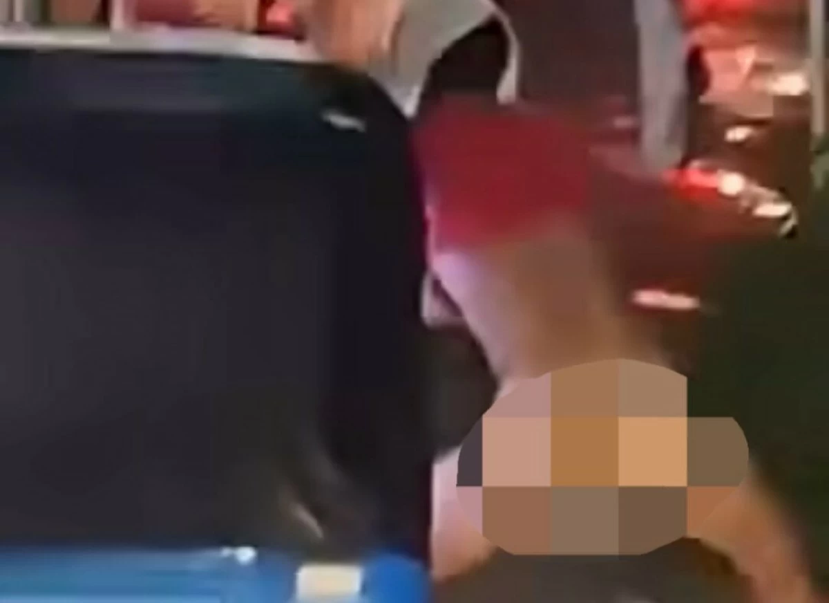 A boy clings to a tricycle while dancing naked. (Screengrab from Erne Medrano/Facebook)