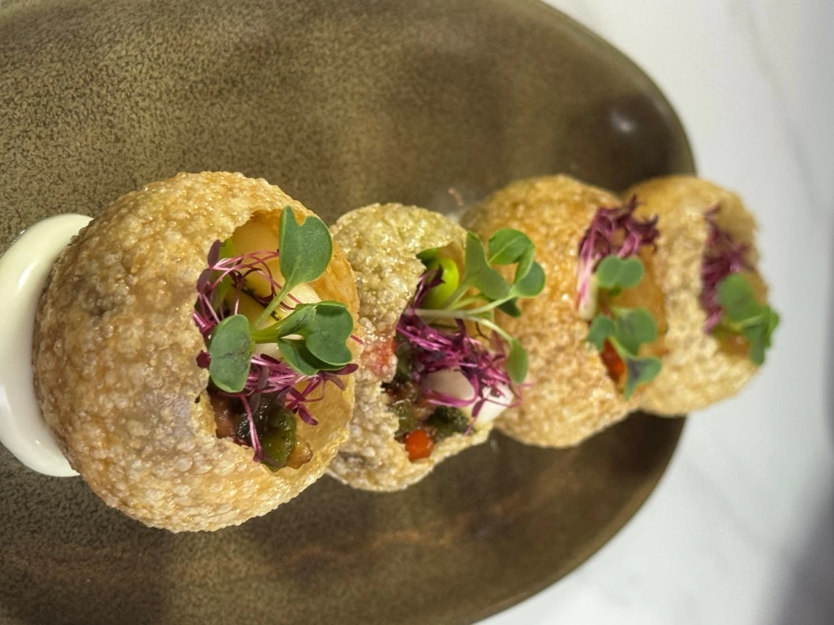 FLAVOR BOMB A single bite of Dinakdakan, reimagined in a crisp panipuri shell with ratatouille relish, sinamak jelly, and edamame, delivers sharp acidity and umami in quick, clean succession.