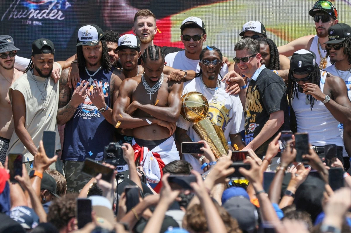 Oklahoma City Thunder players and Oklahoma City Mayor David Holt, right of trophy, pose for photos during a celebration of the Thunder's NBA basketball championship Tuesday, June 24, in Oklahoma City. (AP Photo/Nate Billings)