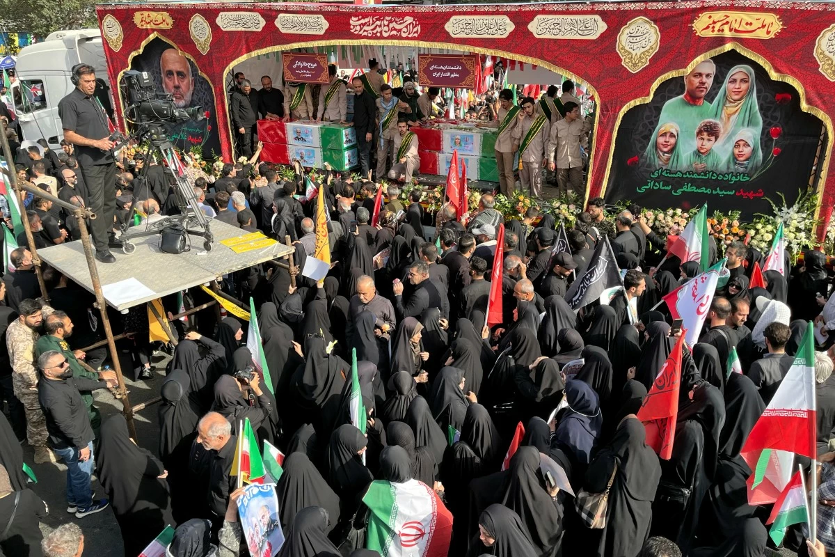 People mourn over the flag-draped coffins of Iranian army generals, nuclear scientists and their family members who were killed in Israeli strikes, during a funeral ceremony in Tehran, Iran, Saturday, June 28, 2025. (AP Photo/Vahid Salemi)