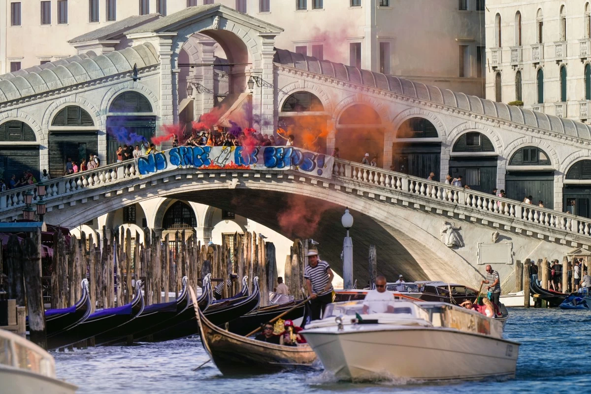 Activists stage a protest on the Rialto Bridge in Venice, Italy, Saturday, June 28, 2025, denouncing the three-day celebrations for the wedding between Jeff Bezos and his wife Lauren Sanchez Bezos that took place in Venice on Friday as a symbol of rising inequality and disregard for the city's residents. (AP Photo/Luca Bruno)