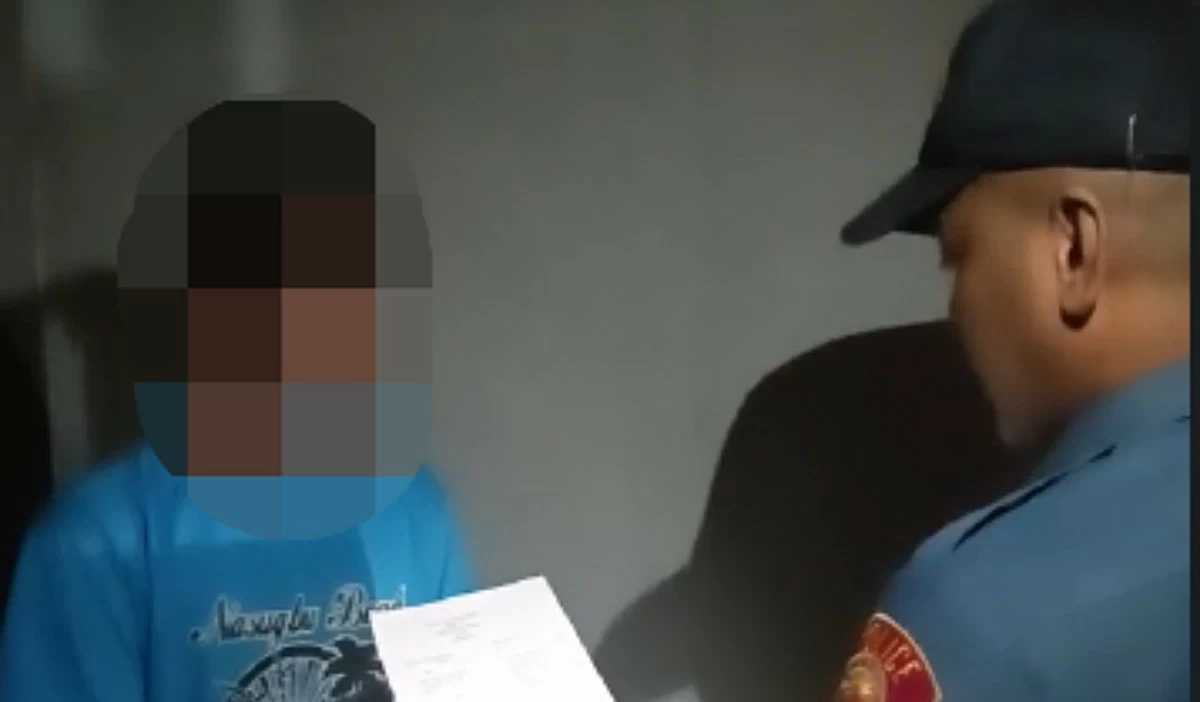 A Muntinlupa police officer with the suspect. (Photo from Muntinlupa police / SPD)