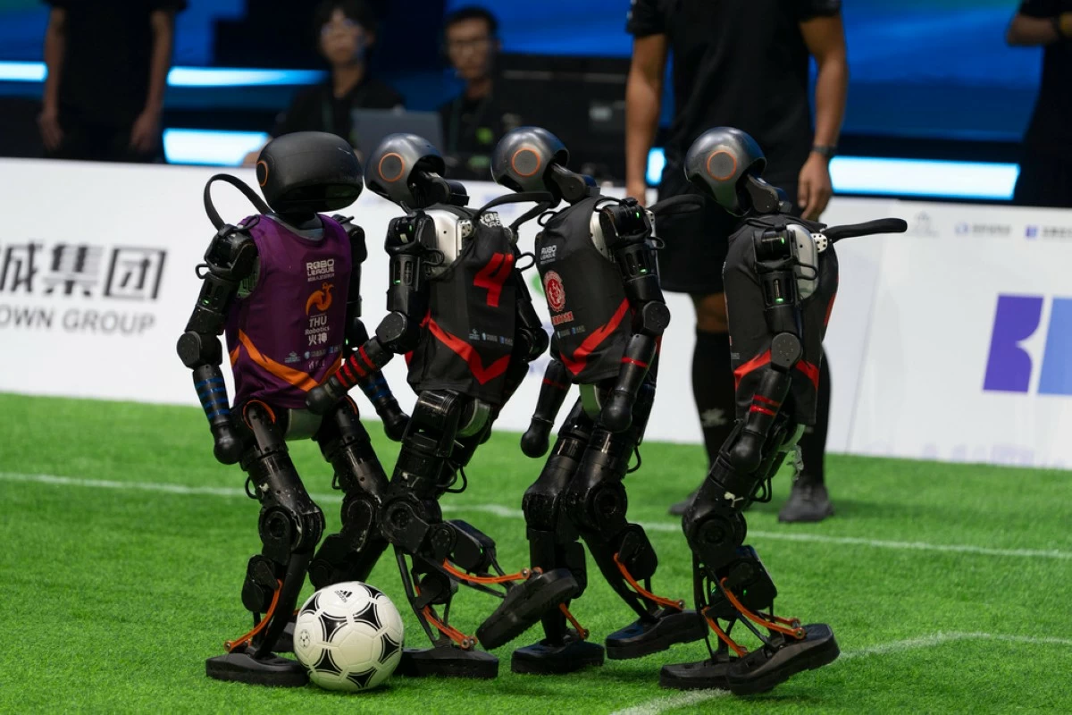 Teams compete using the T1 robots from Booster Robotics during the inaugural RoBoLeague robot soccer competition held in Beijing, Saturday, June 28, 2025. (AP Photo/Ng Han Guan)