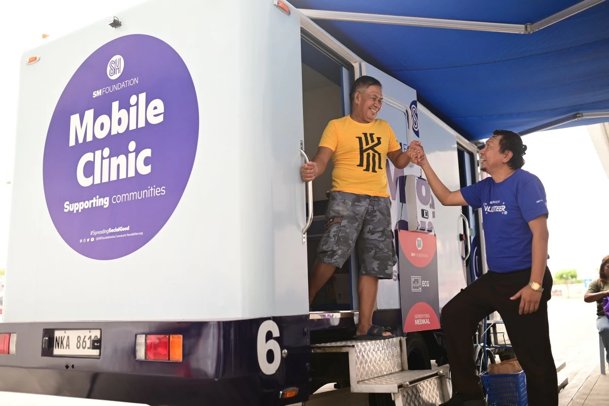 SM Foundation volunteer ensures the patient's safe departure from the mobile clinic after successful X-ray screening
