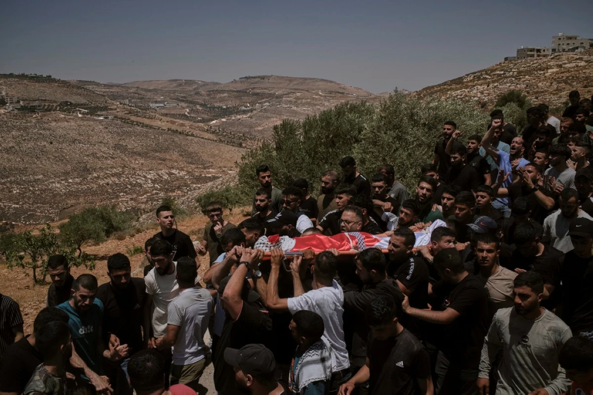 Mourners carry the bodies of three Palestinians who were killed on Wednesday when Jewish settlers stormed the West Bank village of Kafr Malik, Thursday, June 26, 2025. (AP Photo/Leo Correa)