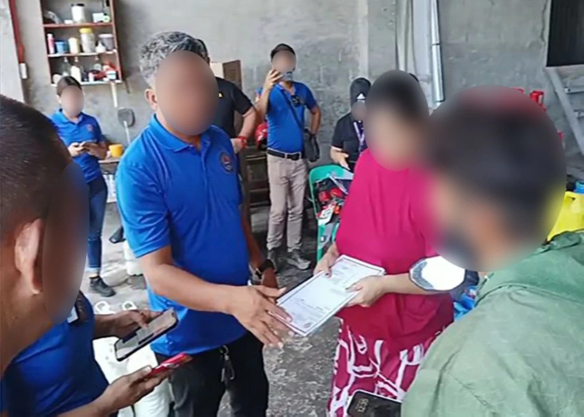 CIDG operatives inform an Indian woman and her son of their arrest for selling smuggled cooking oil during an operation in Santiago City in Isabela. (photo: CIDG) 