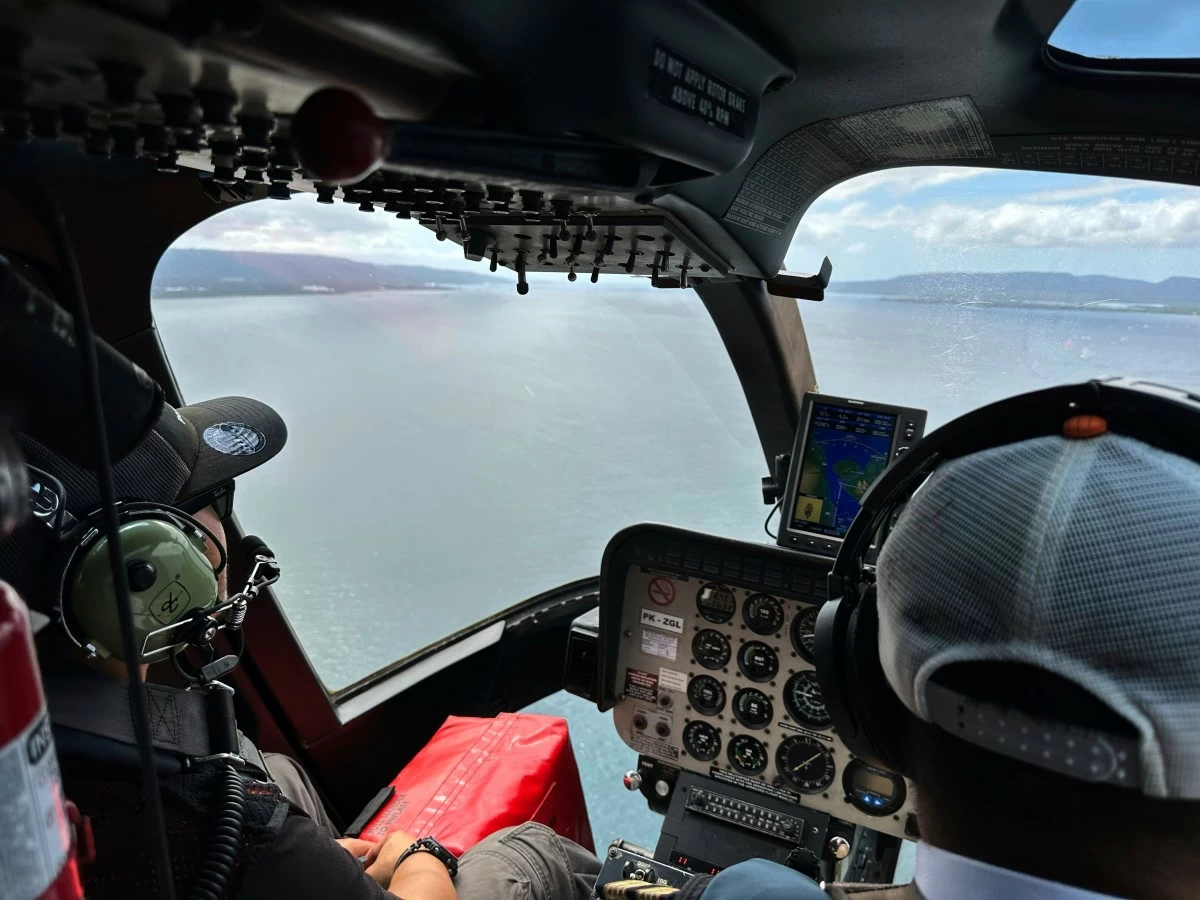 Crew fly a helicopter flying over the Bali Strait during a search operation for the victims of a late Wednesday ferry sinking  near the resort island of Bali, Indonesia, Friday, July 4, 2025. (AP Photo/Firdia Lisnawati)
