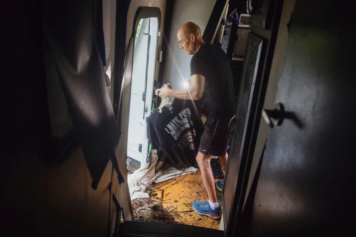 Thomas Rux, a resident of Riverside RV Park, goes through the wreckage of his RV that was swept away by floodwaters in Ingram, Texas, on Friday, July 4, 2025. (Christopher Lee/The San Antonio Express-News via AP)