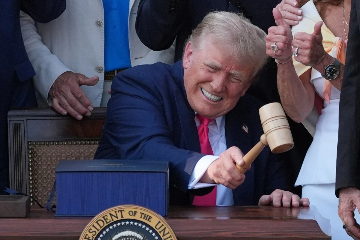 President Donald Trump bangs a gavel presented to him by House Speaker Mike Johnson of La., after he signed his signature bill of tax breaks and spending cuts at the White House, Friday, July 4, 2025, in Washington. (AP Photo/Evan Vucci)