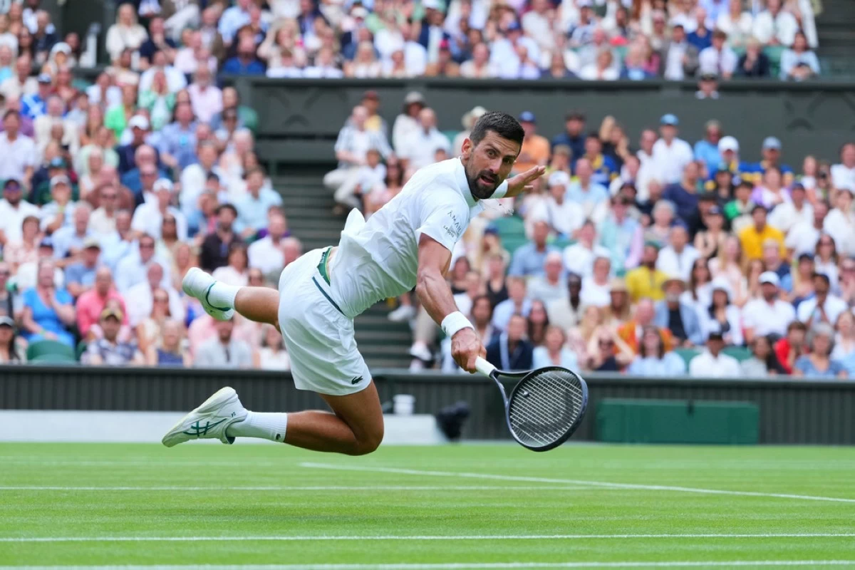 Novak Djokovic of Serbia dives to return to Miomir Kecmanovic of Serbia during a third round men's singles match at the Wimbledon Tennis Championships in London, Saturday, July 5, 2025. (AP Photo/Kirsty Wigglesworth)