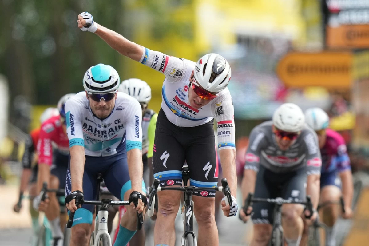 Belgium's Tim Merlier celebrates as he crosses the finish line to win the third stage of the Tour de France cycling race over 178.3 kilometers (110.8 miles) with start in Valenciennes and finish in Dunkerque, France, Monday, July 7. (AP Photo/Thibault Camus)