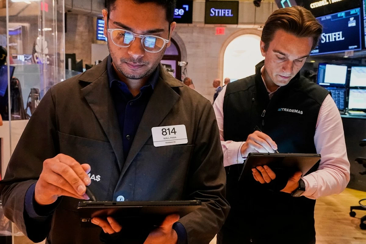Trader Niall Pawa, left, works with a colleague on the floor of the New York Stock Exchange, Tuesday, July 1, 2025. (AP Photo/Richard Drew)
