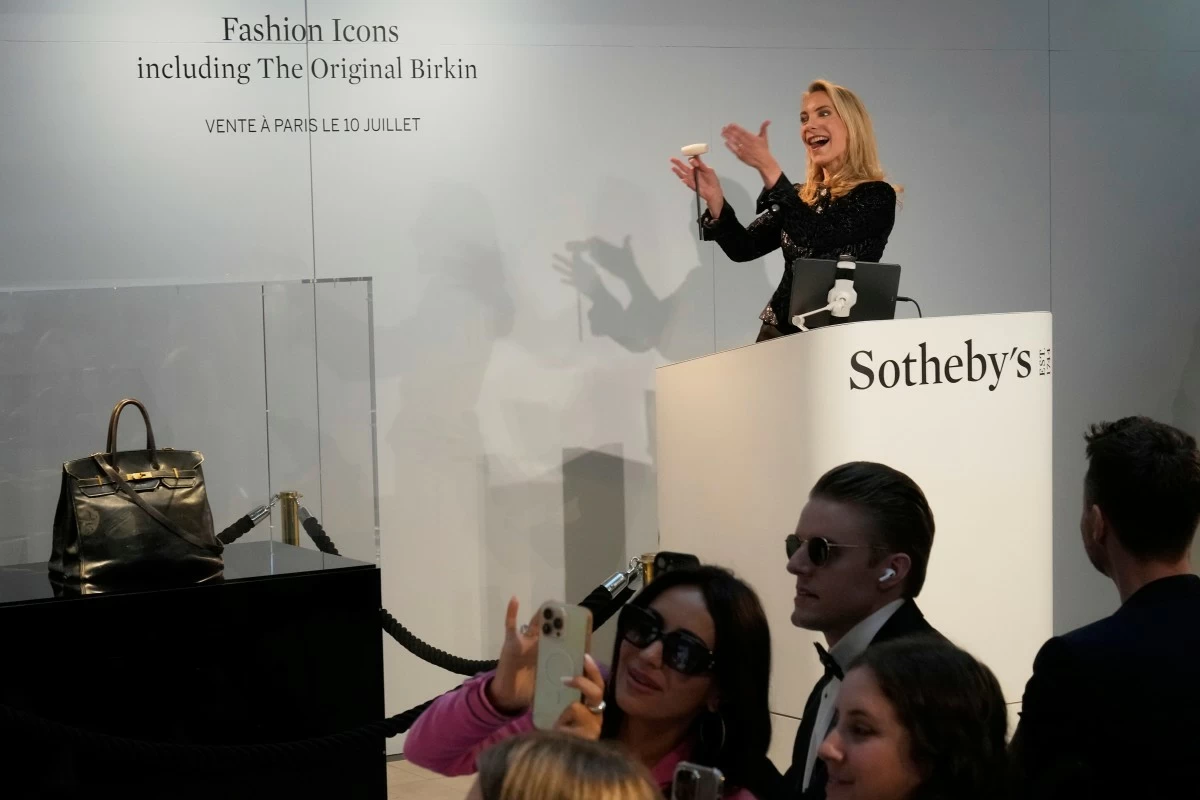 Auction officer Aurélie Vandevoorde gestures as the original Birkin bag created by Hermès for Jane Birkin was sold at auction for 7 million euros or $8.2 million, Thursday, July 10, 2025 in Paris. (AP Photo/Michel Euler)