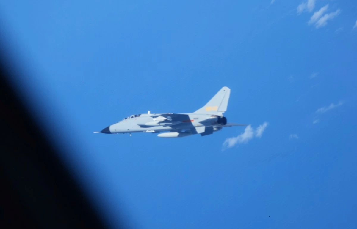 In this photo provided by Japan’s Ministry of Defense, a Chinese JH-7 fighter-bomber, center, is seen close to a YS-11EB electronic-intelligence aircraft, partly seen at left, of the Japan Air Self-Defense Force over the East China Sea on July 9, 2025. (Ministry of Defense via AP)