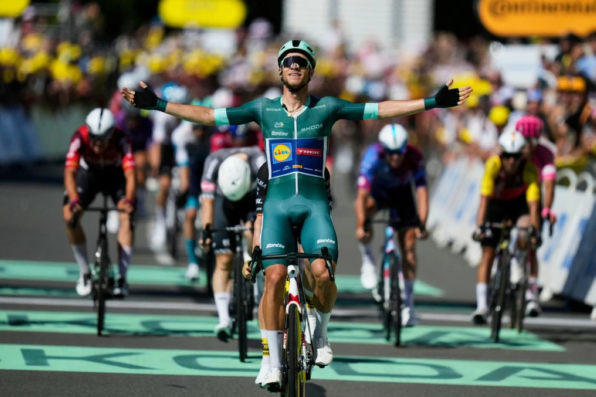Italy's Jonathan Milan, wearing the best sprinter's green jersey, celebrates as he crosses the finish line to win the eighth stage of the Tour de France cycling race over 171.4 kilometers (106.5 miles) with start in Saint-Meen-le-Grand and finish in Laval Espace Mayenne, France, Saturday, July 12, 2025. (AP Photo/Mosa'ab Elshamy)