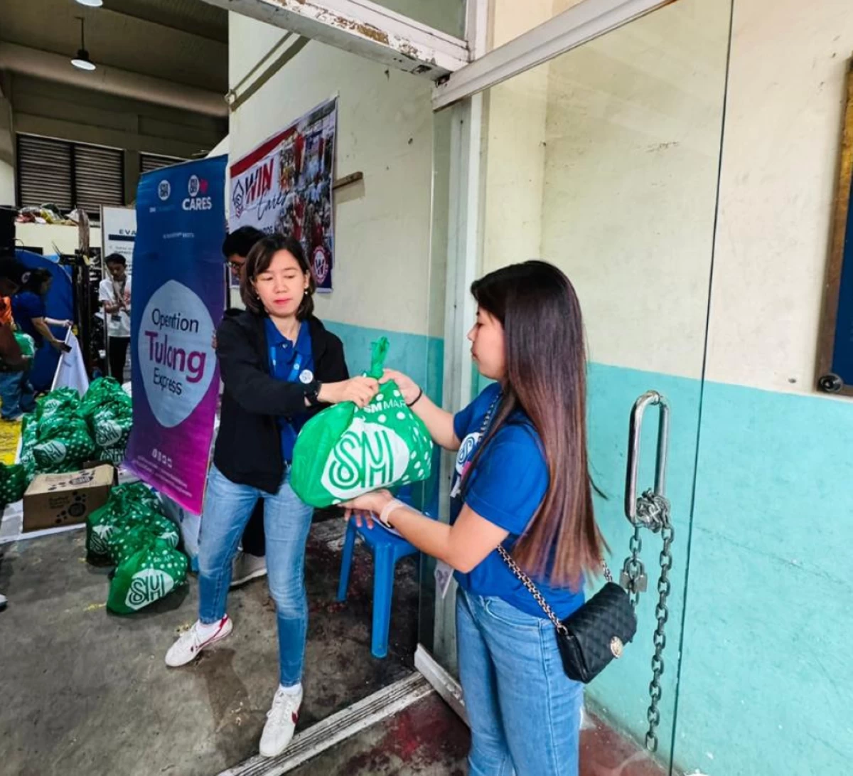 Employee-volunteers of SM City East Ortigas prepares to distribute Kalinga Packs to victims of the that recently hit Barangay Manggahan.