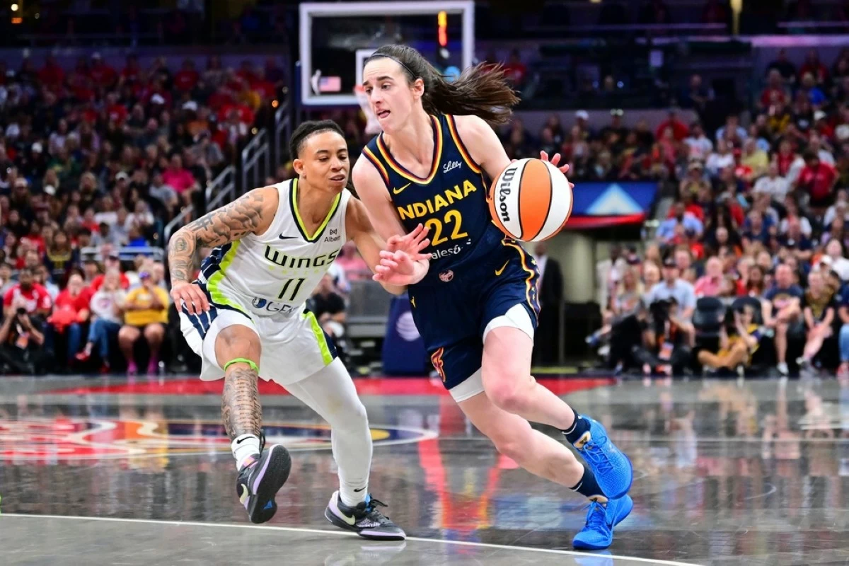 Indiana Fever's Caitlin Clark (22) goes to the basket against Dallas Wings' JJ Quinerly (11) during the second half of a WNBA basketball game, Sunday, July 13, in Indianapolis. (AP Photo/Doug McSchooler)