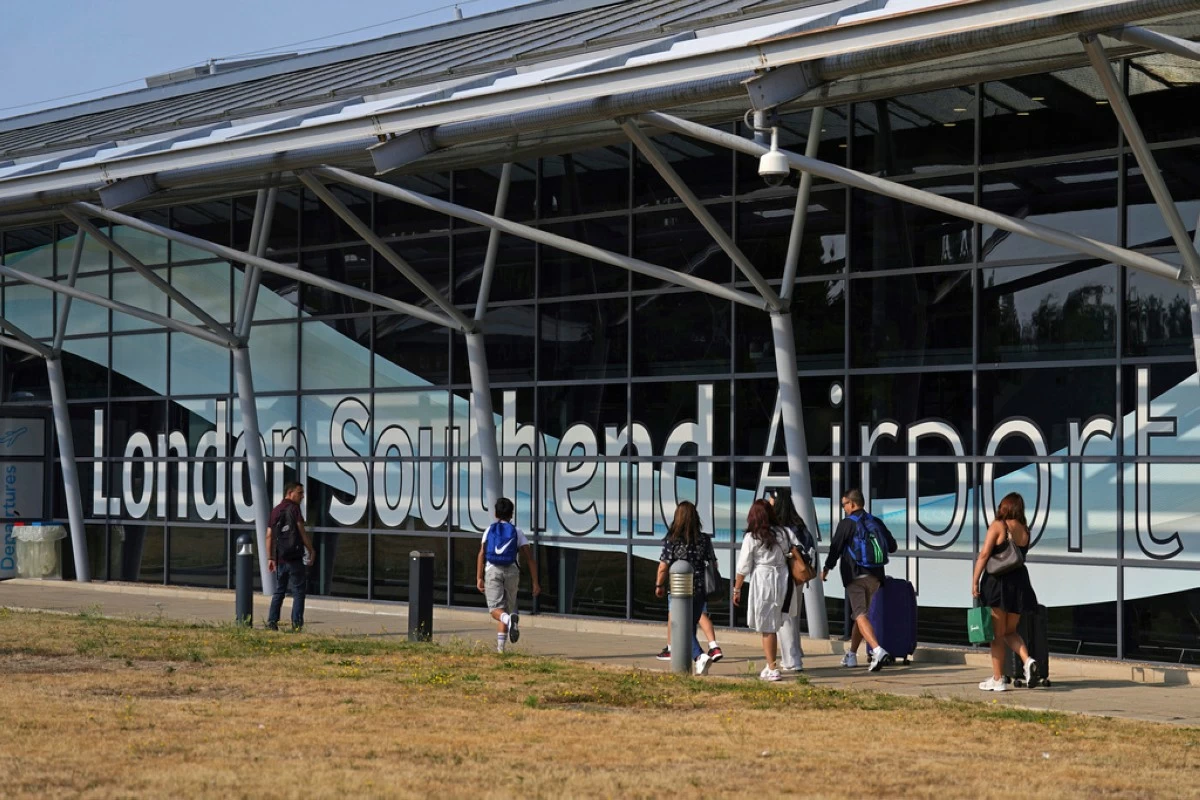 Passengers outside the terminal building at Southend Airport in Essex, where a 12-metre plane crashed shortly after take off on Sunday afternoon, Monday July 14, 2025. (Joe Giddens/PA via AP)