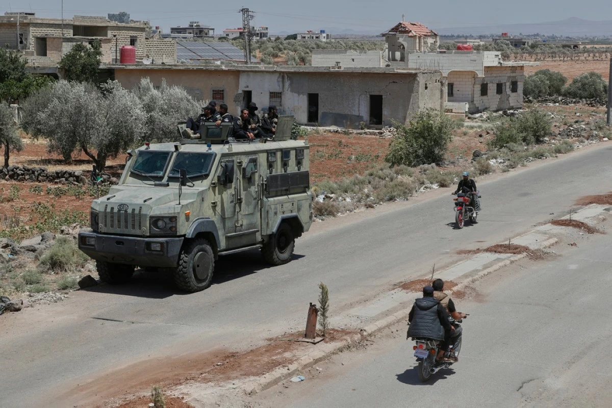 Syrian government security forces sit on their armored vehicle at Busra al-Harir village in Daraa, as they prepare to enter Sweida province where clashes erupted between Druze militias and Sunni Bedouin clans, southern Syria, Monday, July 14, 2025. (AP Photo/Omar Sanadiki)
