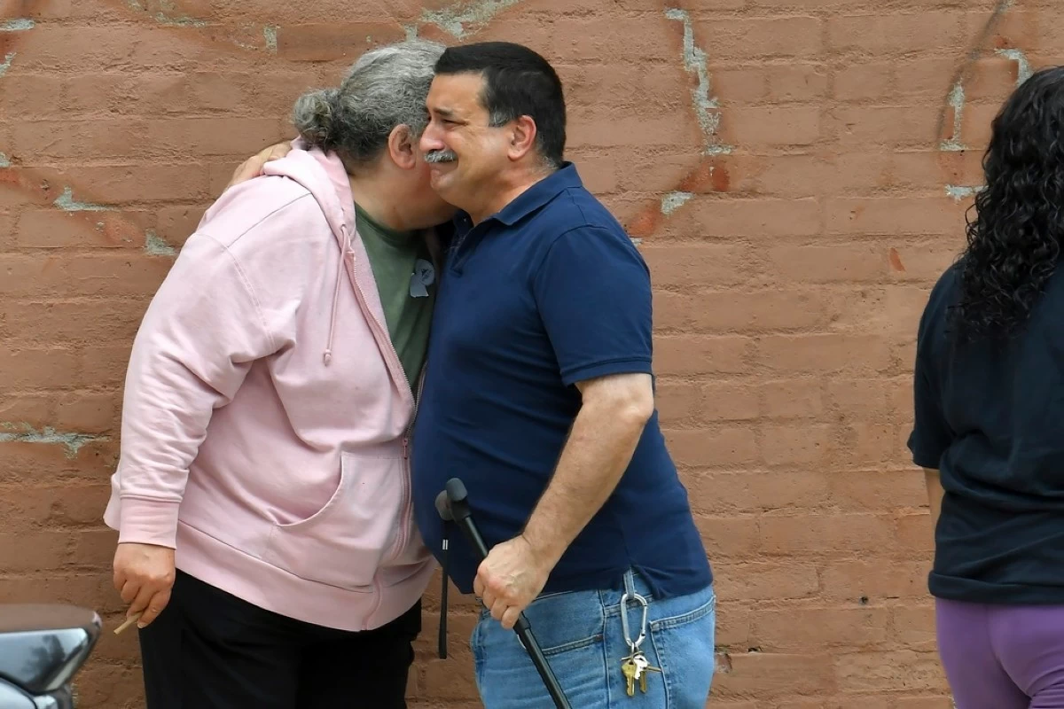 A unidentified man, right, appears emotional while embracing a resident of the Gabriel House assisted living facility, left, in Fall River, Mass., outside a temporary shelter, Monday, July 14, 2025, in Fall River, following a fire at the Gabriel House that started late Sunday and resulted in multiple fatalities. (AP Photo/Steven Senne)