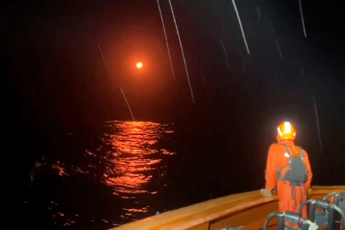 In this undated photo made from video released by the Indonesian National Search and Rescue Agency (BASARNAS) on Tuesday, July 15, 2025, a flare lights up the sky as rescuers search for survivors after a boat capsized on July 14, leaving a number of people missing, in the waters of Sipora Strait in Mentawai Islands, Indonesia. (BASARNAS via AP)