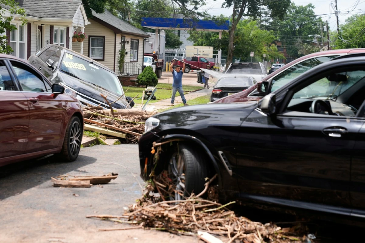 Flood-damaged cars litter a street in North Plainfield, N.J., Tuesday, July 15, 2025. (AP Photo/Seth Wenig)