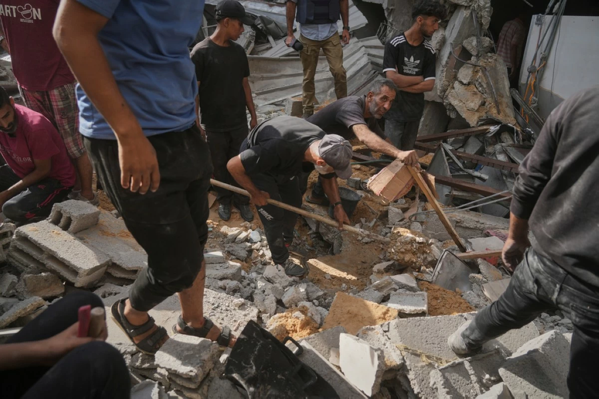 Palestinians search for survivors amid the debris of a building destroyed by an Israeli airstrike in Gaza City, Tuesday, July 15, 2025. (AP Photo/Jehad Alshrafi)