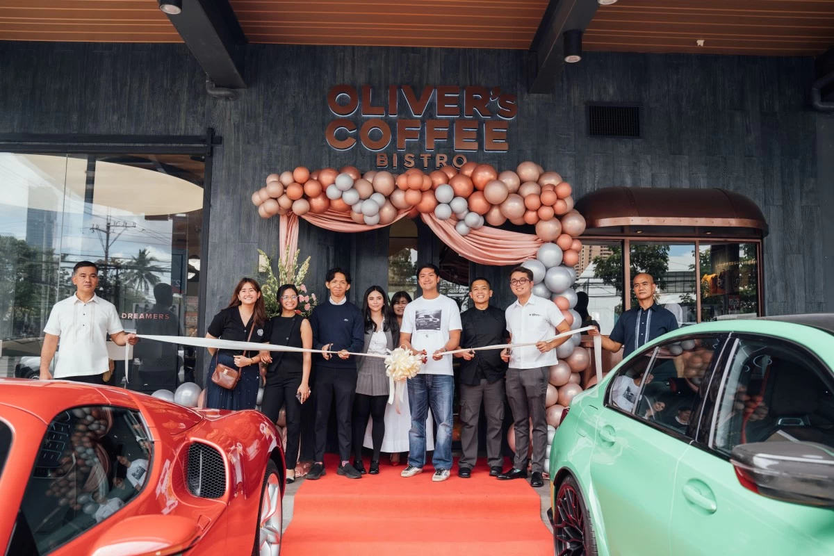 Jakob Ang, center, in a white t-shirt, poses with the Oliver's Coffee family