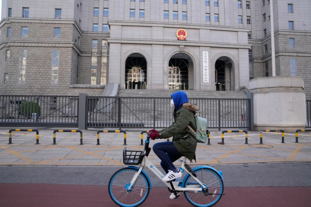 FILE - A cyclist rides past outside the Beijing No.2 Intermediate People's Court, March 31, 2022, in Beijing. (AP Photo/Ng Han Guan, File)