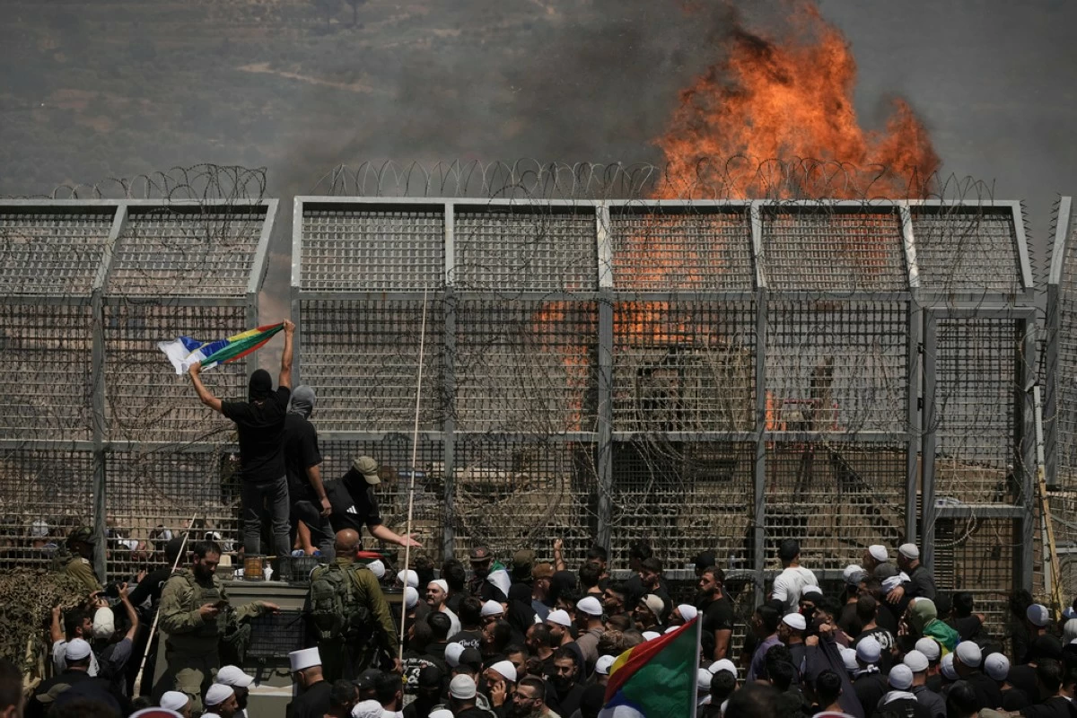 Druze from Syria and Israel protest on the Israeli-Syrian border, in Majdal Shams in the Israeli-controlled Golan Heights, Wednesday, July 16, 2025, amid the ongoing clashes between Syrian government forces and Druze armed groups in the southern Syrian city of Sweida. (AP Photo/Leo Correa)