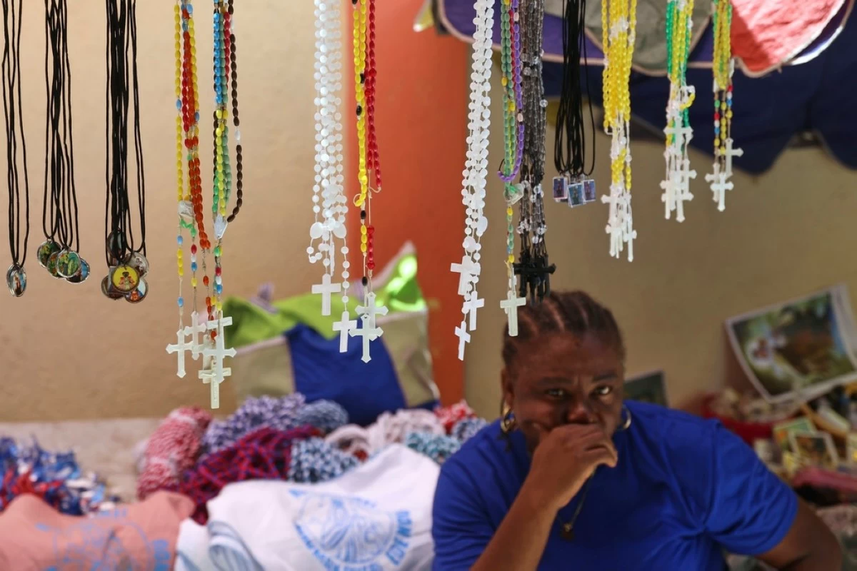 Rosaries for sale hang from a vendor's stand at the entrance of the Mount Carmel Church during a Mass marking the feast day of Our Lady of Mount Carmel, in the Petion-ville neighborhood of Port-au-Prince, Haiti, Wednesday, July 16, 2025.(AP Photo/Odelyn Joseph)