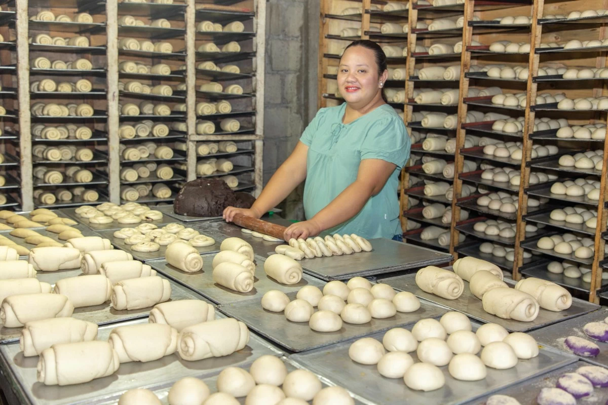 An ASA Philippines Nanay member proudly works in her thriving bakery, a business grown through the foundation's Microbusiness Financing program. Through her hard work and ASA's support, she is not only providing employment for her community but also uplifting her family and securing their future.