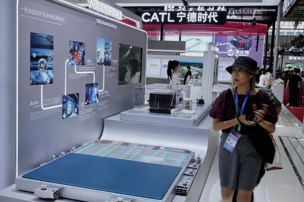 Visitors walk in front of a CATL Naxtra battery is seen at a CATL booth during the 3rd China International Supply Chain Expo at the China International Exhibition Center, in Beijing, China, Friday, July 18, 2025. (AP Photo/Mahesh Kumar A.)