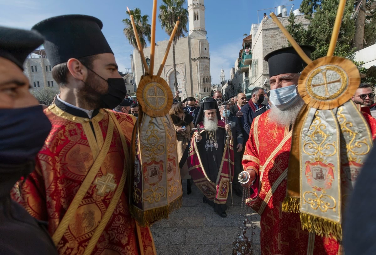 FILE -Greek Orthodox Patriarch of Jerusalem Theophilos III, center, arrives for Christmas celebrations, according to the Eastern Orthodox calendar, outside the Church of the Nativity, traditionally recognized by Christians to be the birthplace of Jesus Christ, in the West Bank city of Bethlehem, Jan. 6, 2021. (AP Photo/Nasser Nasser), File)