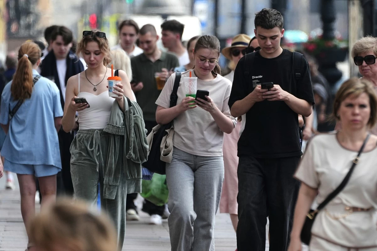Pedestrians look at their phones while walking through St. Petersburg, Russia, on Monday, July 14, 2025. (AP Photo/Dmitri Lovetsky)
