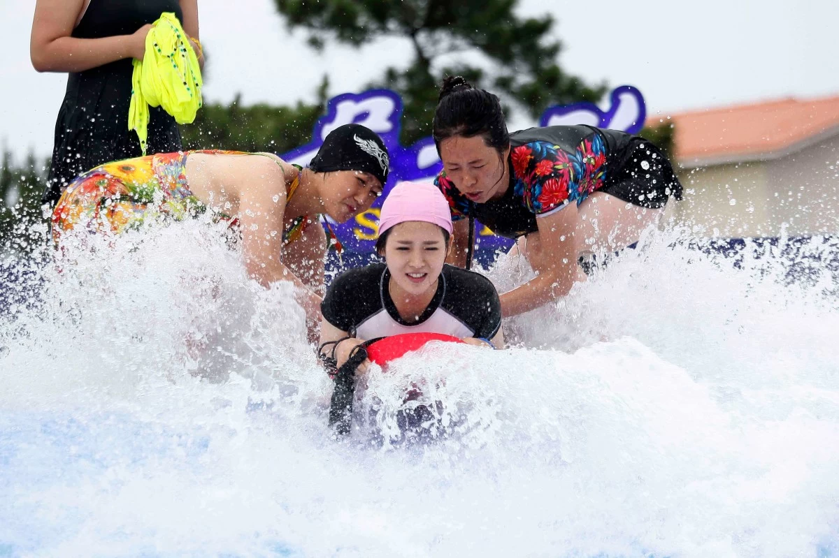 A women plays in the water  at the Myongsasimni Water Park of the Wonsan Kalma Coastal Tourist Area in Wonsan, Kangwon Province Wednesday, July 2, 2025. (AP Photo/Cha Song Ho)