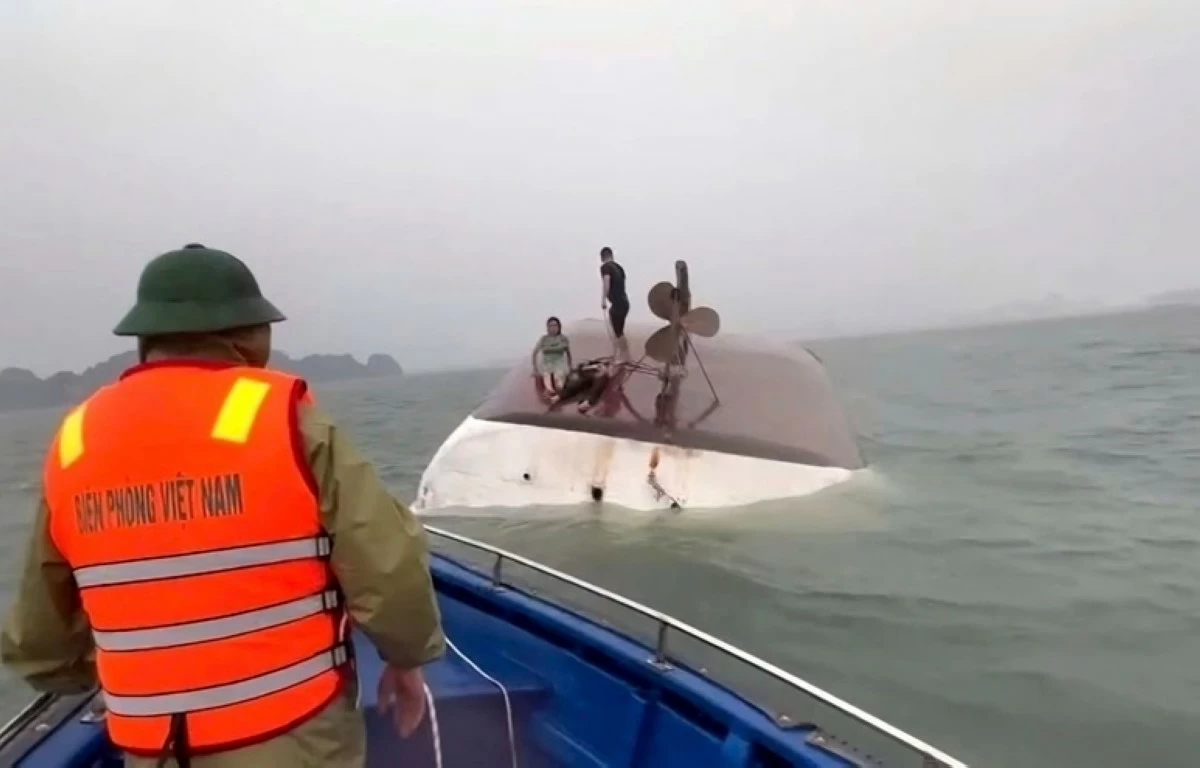 This image from a video provided by QDND shows people on a capsized tourist boat being rescued in Ha Long Bay, Vietnam on Saturday, July 19, 2025. (QDND via AP)