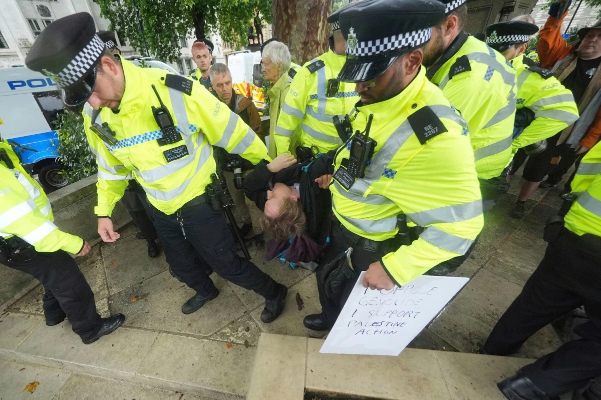 Metropolitan Police officers remove a demonstrator from a protest in Parliament Square in support of Palestine Action, organised by Defend Our Juries who are campaigning to de-proscribe the organisation, in London, Saturday July 19, 2025. (Yui Mok/PA via AP)