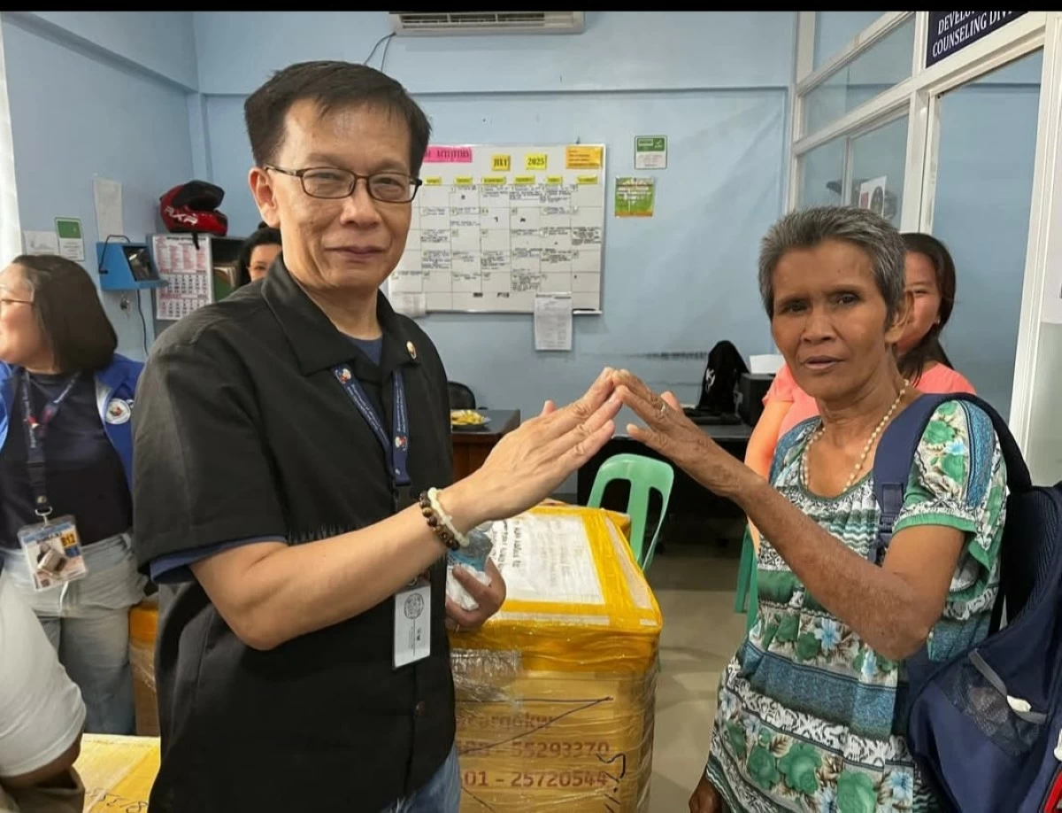 DMW Secretary Hans Leo Cacdac personally turns over a balikbayan box to a family in Kidapawan City. (photo: DMW)