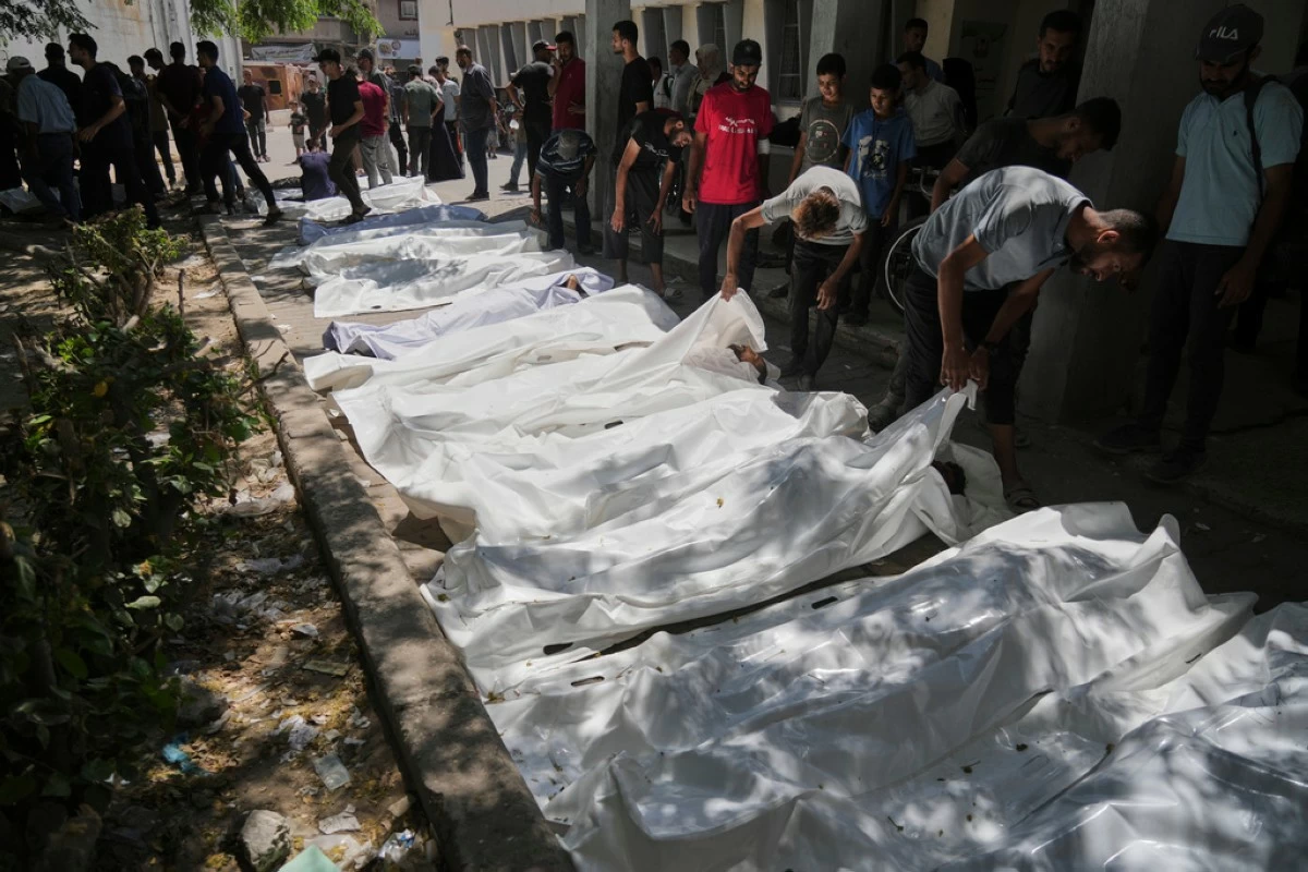 The bodies of Palestinians who were killed while attempting to access aid trucks entering northern Gaza through the Zikim crossing with Israel are brought to a clinic in Gaza City, Sunday, July 20, 2025. (AP Photo/Jehad Alshrafi)