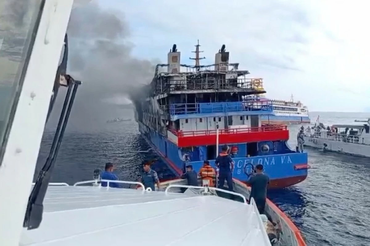 In this photo made from video released by the Indonesian National Search and Rescue Agency (BASARNAS), rescue ship approach passenger ship KM Barcelona after it caught fire in the waters off Talise Island in North Sulawesi, Indonesia, Sunday, July 20, 2025. (BASARNAS via AP)