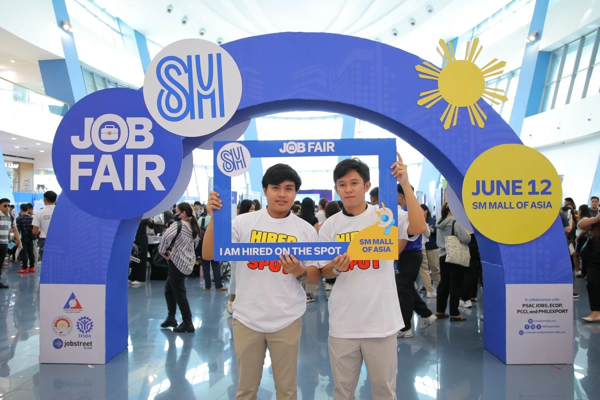 Job applicants pose with a Hired-on-the-spot frame at the job fair in SM Mall of Asia.
