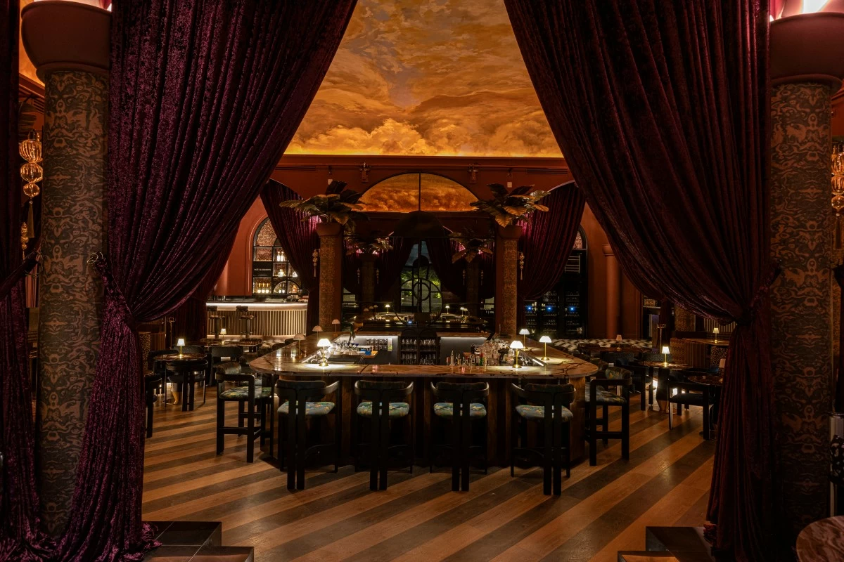 VELVET HOUR Medusa’s main room blends Art Deco lines with tropical warmth, featuring a sculptural oval bar, moody lighting, and layered textures.
