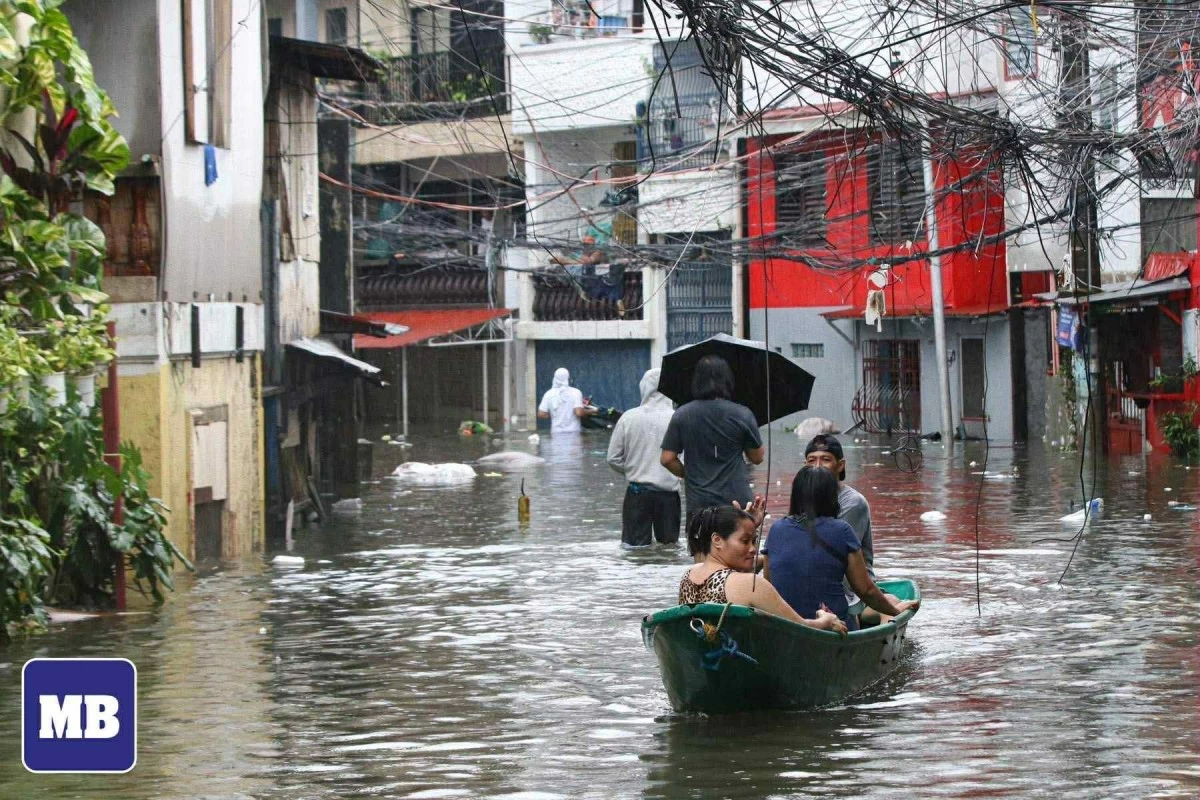 Residents of Barangay Roxas District in Quezon City wade through floodwaters caused by continuous heavy rains brought by the southwest monsoon, locally known as habagat, on Tuesday, July 22, 2025. (Santi San Juan/MANILA BULLETIN)
