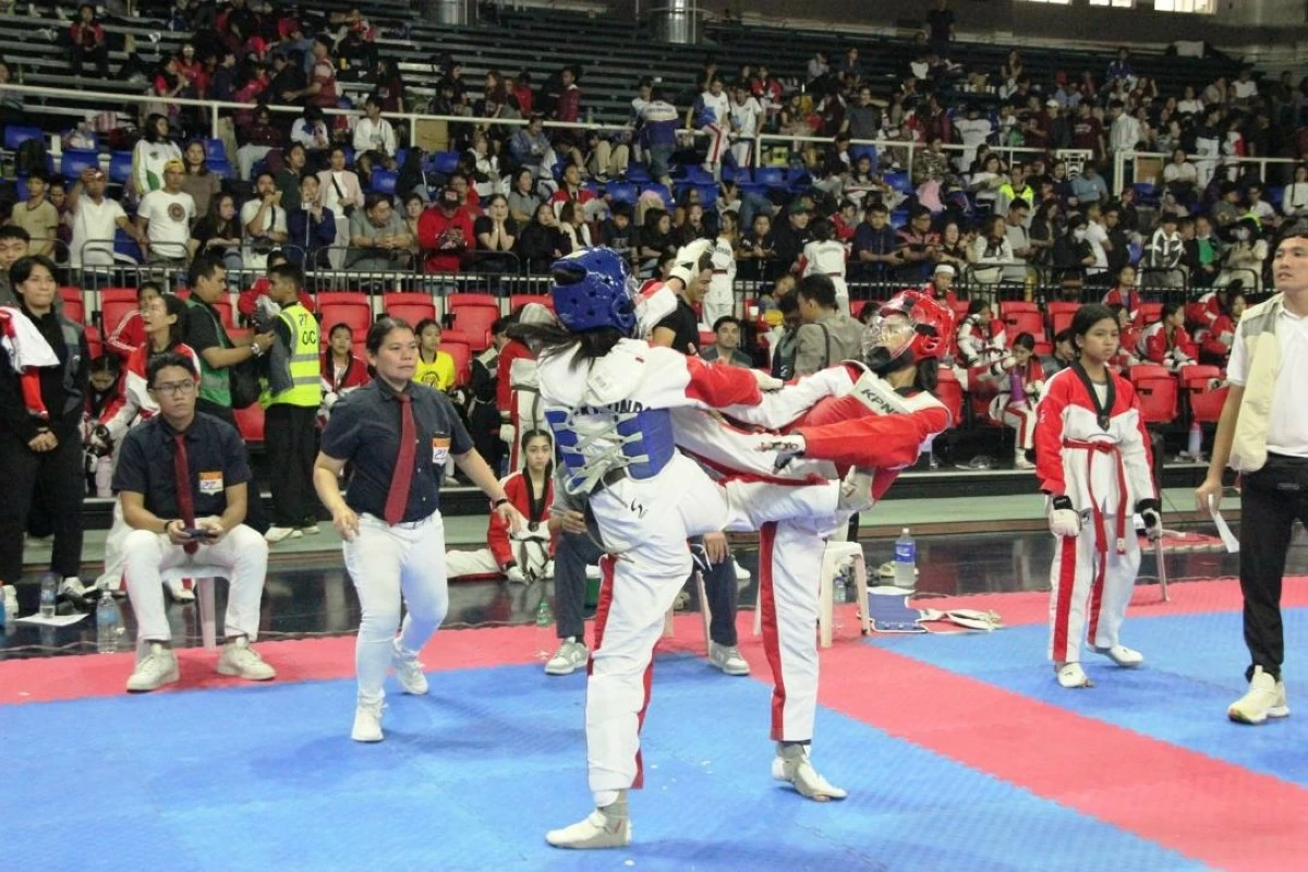 Female jins engage each other in an intense action with both aiming to score a point during a tournament by the Philippine Taekwondo Association.