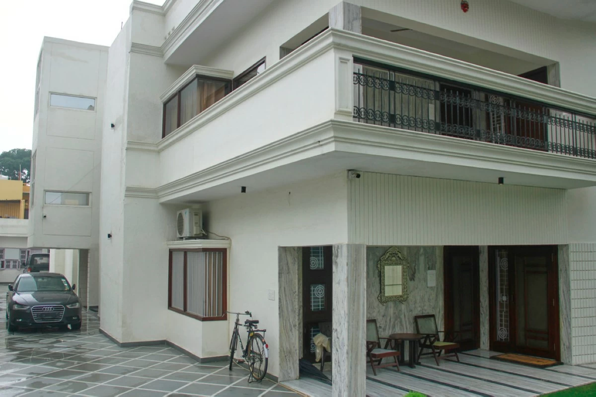 A luxury car and a bicycle are seen parked outside a rented residential building in which a bogus embassy was running in Ghaziabad, outskirts of New Delhi, India, Wednesday, July 23, 2025. (AP Photo)