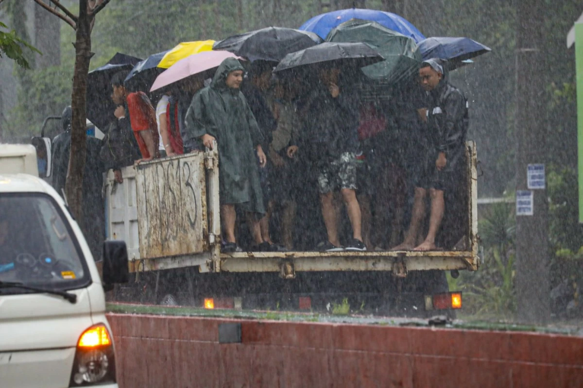 Stranded passengers find a way to get to their destinations amid the massive flooding in Cainta, Rizal through a free ride provided by the local government on July 22, 2025. (John Louie Abrina)