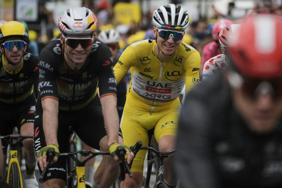 A smiling Tadej Pogacar of Slovenia, wearing the overall leader's yellow jersey, crosses the finish line with Belgium's Wout van Aert, second left, and Britain's Simon Yates, far left, during the twentieth stage of the Tour de France cycling race over 184.2 kilometers (114.5 miles) with start in Nantua and finish in Pontarlier, France, Saturday, July 26, 2025. (AP Photo/Thibault Camus)