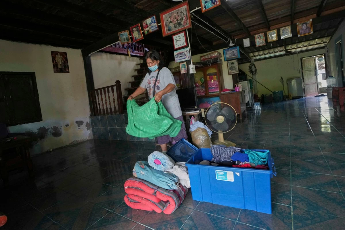 Kalwalin Jindasri who had fled home following the clashes between Thai and Cambodian soldiers, arranges her belongings after returning home in Surin province, Thailand, Tuesday, July 29, 2025 after the ceasefire was supposed to take effect at midnight on  July 28, 2025. (AP Photo/Sakchai Lalit)